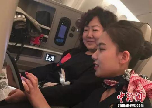 空乘人员指导乘客连接机上Wifi。图片来源 中新网 空乘人员指导乘客连接机上Wifi。图片来源 中新网
