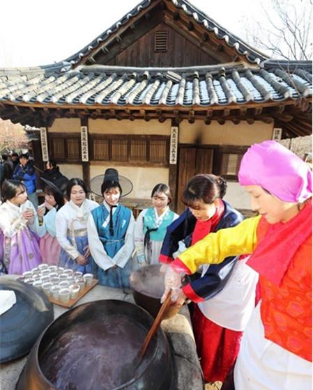 韩国提前庆冬至:民俗村熬红豆粥 美女游客排队领