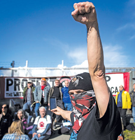 示威者在本那比康德摩根外举拳抗议.(加新社)