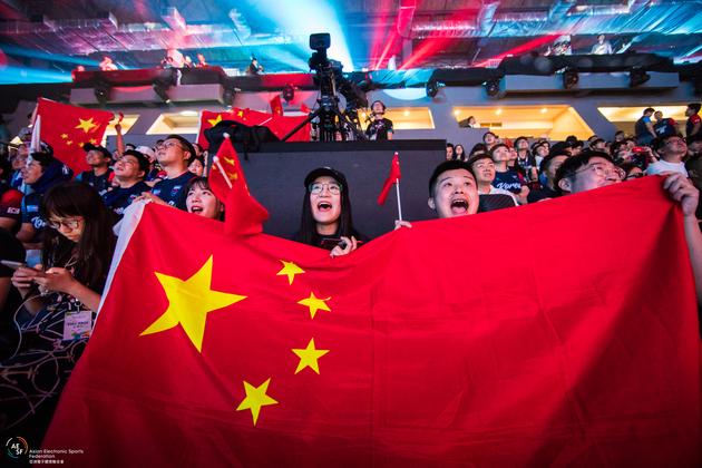 雅加达亚运会现场,中国观众激动的为中国电竞选手摇旗呐喊加油(腾讯