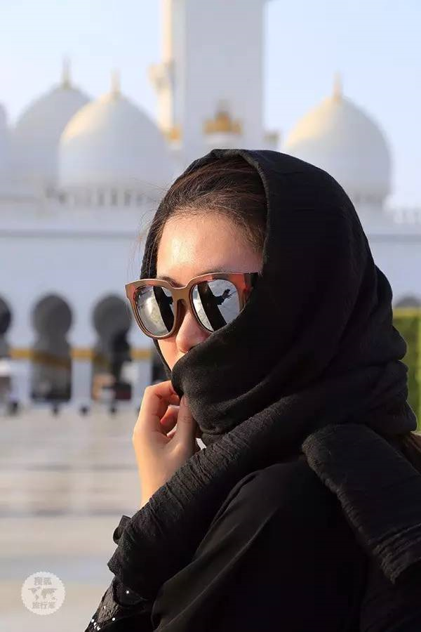 当地的男性身着白袍,当地的女性身着黑袍,戴黑色头纱和面纱,看起来